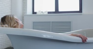 Sakin, seksi genç bir kadın lüks bir banyoda yatıyor, genç sarışın kız uykuya dalıyor, suç, yorgunluk rahatlama, dikkatsizce hayat yavaş çekimde intihar ediyor.