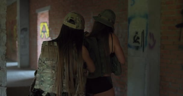 Två Militära Flickor Håller Automatiska Gevär Och Promenader Övergiven Byggnad — Stockvideo