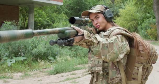 Zelfverzekerde Gewapende Vrouw Camouflage Koptelefoon Houdt Sluipschuttersgeweer Vast Mikt Vijandelijke — Stockvideo