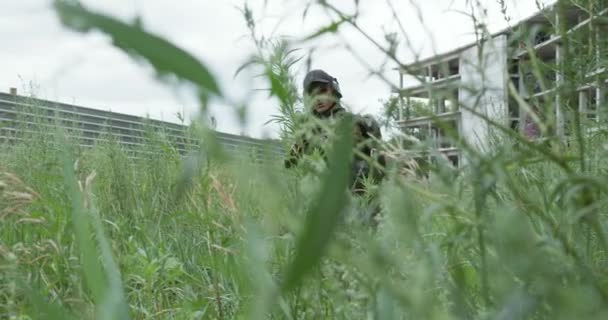 女軍狙撃手が歩い草の中で彼女のライフルを運ぶ スローモーション 兵士は屋外で敵を探しています — ストック動画