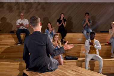 Kafkasyalı Kanepe Profesörünün Resmi Takım Elbisesi, Eğitim ve Çalışma Konsepti 'nden bahsettikten sonra çok ırklı insanlar el çırpıyor. Modern Konferans Salonu, Üniversite Konferans Salonu
