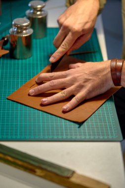 Bıçakla cilt ürünleri yetiştirme ustası. Küçük işletmeler, yakın çekim, deriyle çalışma süreci.