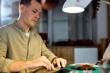 Ciddi bir zanaatkar deri cüzdanını parlatmış. Yan görüş açısını kapat. Adamın deri cüzdanı var.