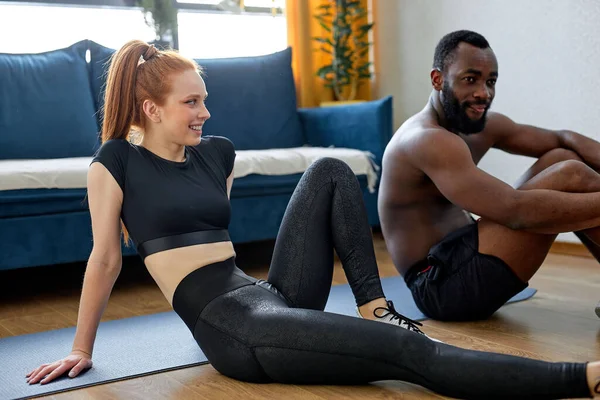 混血种族夫妇一起锻炼 红头发的高加索女人和黑人肌肉裸男在家锻炼后 休息一下 青少年健康 培训和生活方式概念 — 图库照片