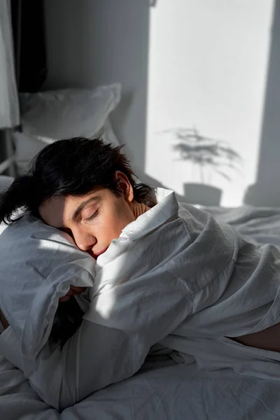 Νεαρός Μελαχρινός Άντρας Που Κοιμάται Βαθιά Στην Κρεβατοκάμαρα Αγκαλιάζει Μαξιλάρι — Φωτογραφία Αρχείου