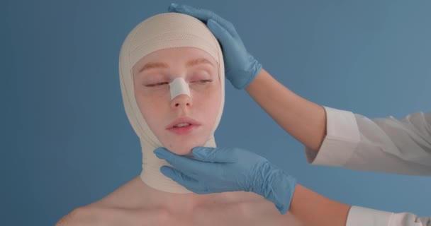 Врач Проверяет Лицо Женщины После Успешной Пластической Операции Доктор Синих — стоковое видео