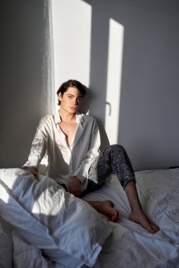 Yatak odasındaki kameraya bakan tembel, genç, çekici, yorgun bir adam. Tam yol ileri. Yorgunluk, depresyon