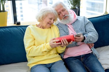 Evde sesli bir sanal müzik hoparlörü kullanarak birlikte eğlenen heyecanlı, olgun bir çift. Gündelik giysiler içinde beyaz eşler hafta sonlarının tadını çıkarırlar, modern teknolojileri kullanmayı öğrenirler.