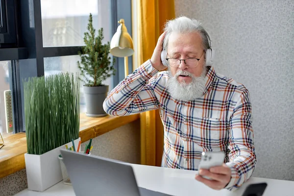 Пожилой Человек Сидит Расслабиться Уютной Комнате Просматривая Интернет Современном Ноутбуке — стоковое фото