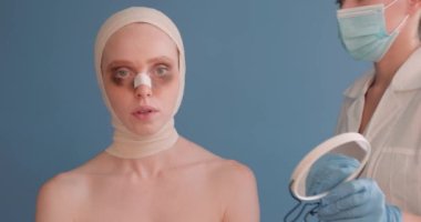 Yüzü yara bere içinde üzgün bir kadının portresi aynaya sarılı bir kadın aynaya bakıyor, estetik ameliyattan sonra acı çekiyor.