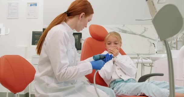 Испуганная Маленькая Пациентка Руками Губах Дает Врачу Сверлить Зубы Рыжая — стоковое видео