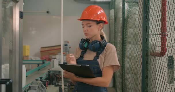 Trabajadora Seria Casco Naranja Ropa Protectora Sosteniendo Carpeta Contando Trabajando — Vídeos de Stock