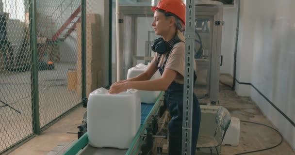 在农业除草剂厂 妇女正在把水壶放在传送带上 — 图库视频影像
