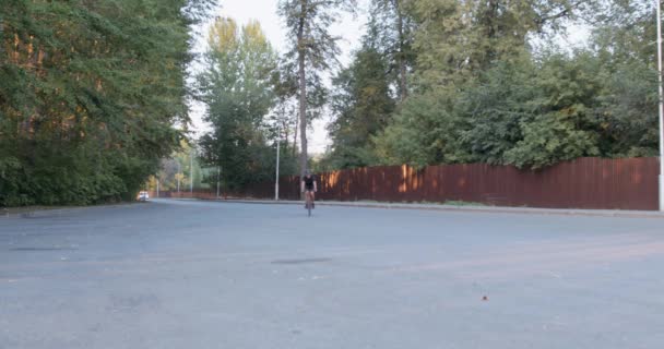 スポーツウェア 保護ヘルメット ミラーガラスを身に着けている若い男が黒い自転車でスポーツ活動を楽しんで筋肉フィット 高速でレース ソフトフォーカス — ストック動画