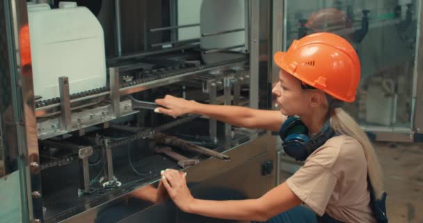 在工厂修理机器时 用螺栓扳手在耳机和头盔中刻苦工作的年轻女技师 关闭了女人像概念农业化工公司 — 图库视频影像