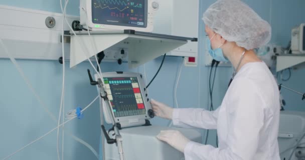 医生或女护士在医院的急诊病房照顾病人 看着屏幕上的屏幕控制设备 麻醉师跟踪身体的重要功能 — 图库视频影像