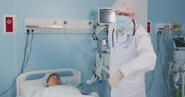 Acil servis: Yaşlı doktor hasta ölürken hemşireden yardım istiyor, zayıf adam kendini kötü hissediyor, buraya gel, jest yap. İlk yardım, hayat kurtarmak, dikkat. Doktorlar yatakta yatan erkek hastayı muayene ediyor.