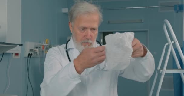 Stary Doświadczony Starszy Lekarz Zakładający Czapkę Kapelusz Szpitalu Przygotowujący Operacji — Wideo stockowe