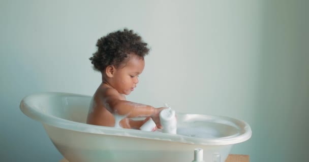 Маленький Симпатичный Черный Малыш Сидящий Ванне Моющийся Играющий Мыльной Пеной — стоковое видео