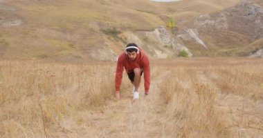 Spor giyim sektöründe yakışıklı bir adam sahada koşmak için bir yarış başlatıyor. Aktif sakallı erkek temiz hava eğitimi için boş zaman harcıyor. İnsan konsantre olur ve nefes alır..