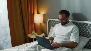 Genç ve mutlu bir kadın, oturma odasında yatakta oturan sakallı kocaya pozitif hamilelik testi uygular. Ağır çekimde, erkek iyi haberlere sevinir, sarılır, karısını ağır çekimde kucaklar.