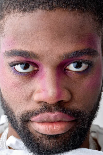 stock image Male makeup look. close-up portrait of beautiful black young man with pink eyeshadow make-up. black american feminine womanlike guy confidently looking at camera. models, beauty, fashion concept