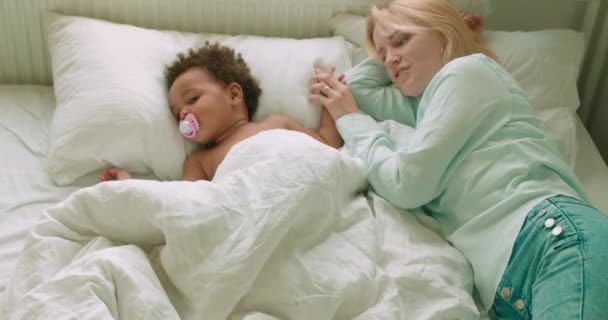 Расслабленная Мама Лежит Кровати Пытаясь Сделать Очаровательный Ребенок Спать Второй — стоковое видео