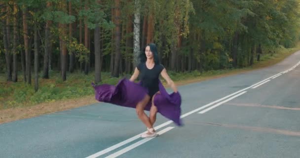 Niesamowite Szczupła Kobieta Czarnym Garniturze Ciała Skacząc Przez Drogę Lesie — Wideo stockowe