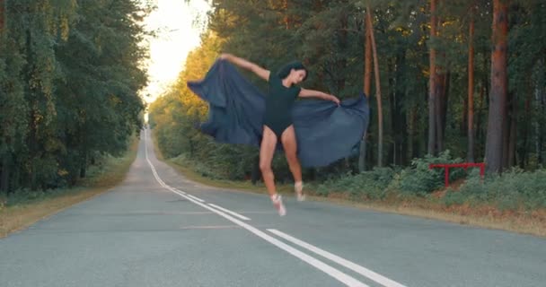 才能のあるダンサーが屋外に飛び出しスローモーション 空を舞うダンサー 森の中で優雅なバレリーナダンスパフォーマンス — ストック動画