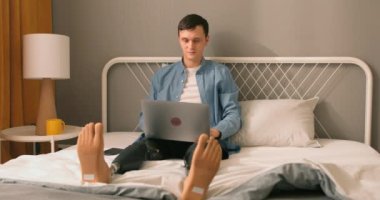 Protezli genç bir adam internette çalışıyor, ders alıyor, çay içiyor, dinleniyor, yatakta oturuyor. Fiziksel engelli, kendine güveni tam beyaz bir adam internette çalışıyor. Asla konseptten vazgeçme