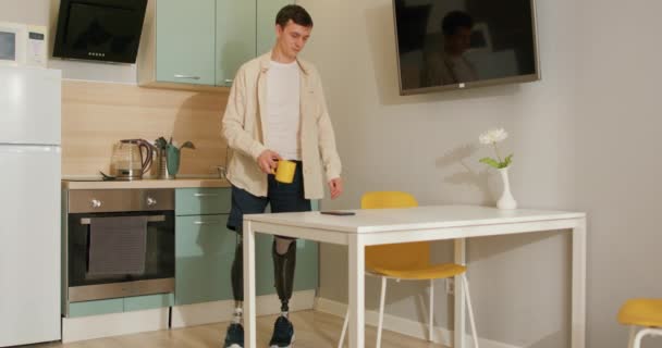 Pohledný Zdravotně Postižený Muž Bionickou Protézou Chytrých Nohou Sedí Kuchyni — Stock video
