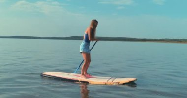 Fit Mutlu Sarışın Kadın Yüzme Teknesi Spor Salonu Su Seyahati Turizmi Tatil Tatili. Spor Eğlencesi Kürek Çekme. Yüzen Yemek Kurulu Turist Yüzen Ayakta Yüzen Raket Kurulu