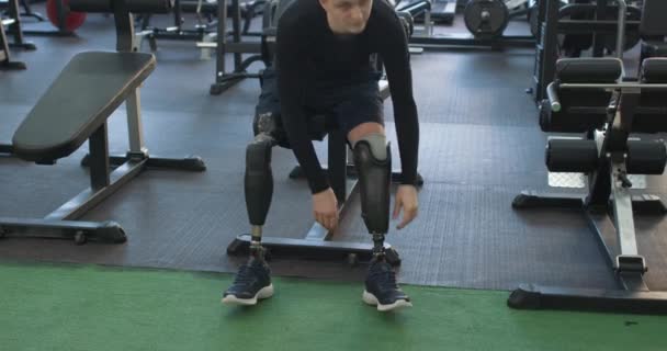 Jovem Deficiente Com Prótese Pernas Amputadas Sentado Ginásio Câmera Lenta — Vídeo de Stock