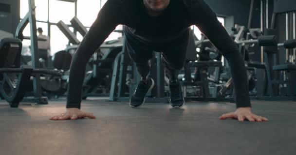 ジムでの人工足のトレーニングとプッシュアップを行う強力な障害のあるスポーツマンスローモーションウォーミングアップや体重の演習を行う 動機づけの健康と体のケアの強さライフスタイル — ストック動画