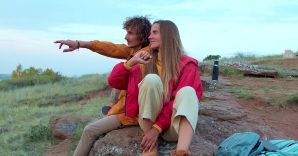 하이킹을 남녀는 가리키는 산위에서 휴식을 취하고 바라보고 건강을 즐기며 여행을 — 비디오