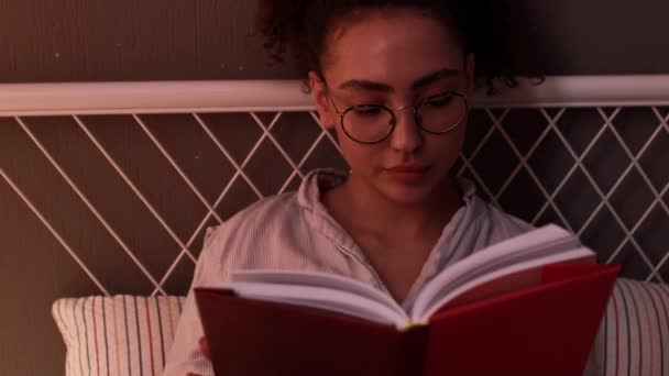 白种人美女睡前专心致志地阅读小说 躺在床上看书 动作缓慢 是书虫的特写 — 图库视频影像