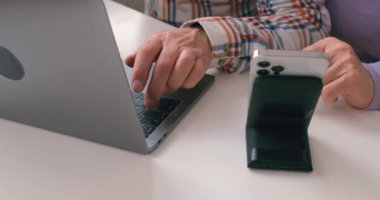 Yaşlı kadın ve erkek eller modern teknolojiler, aletler, jenerasyon ağır çekimde yaşlı çift evde dizüstü bilgisayar ve akıllı telefon kullanıyorlar.