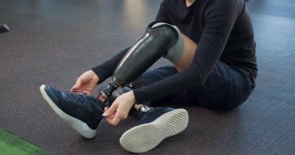 Молодий Спортсмен Штучними Ногами Розкладає Взуття Спортзалі Повільний Рух Хлопець — стокове відео