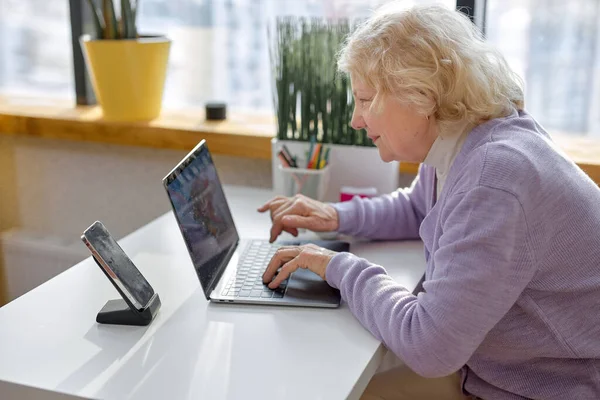 Красивая Пожилая Женщина Сидящая Одна Используя Современный Ноутбук Будет Иметь — стоковое фото