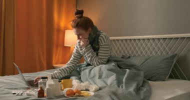 Hasta, soluk, kızıl saçlı, yatağında uzanmış televizyon kumandası açık, televizyonu kapatıyor, ağır çekim zayıflığı var.