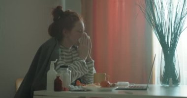 Sağlıksız bir kız burnunu sümkürüyor. Oturma odasında oturuyor. Yorgunluk hastalığı.