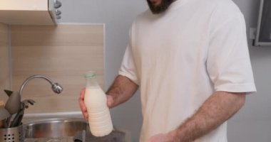 Çalışkan adam elinde bir şişe taze süt tutuyor, una, yumurtalara ekliyor, hamur işi yapmayı öğreniyor, hamur işi yapıyor, yavaş çekimde kamerayı kapatıyor.