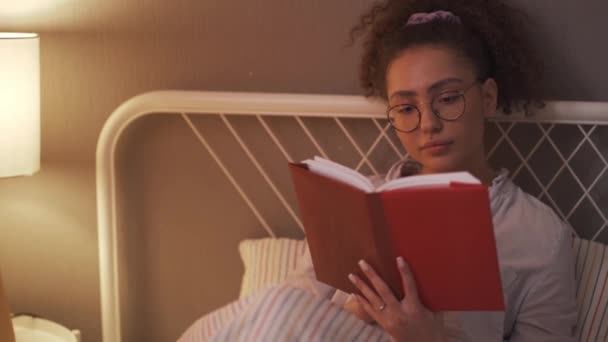 非常棒的年轻女人在睡觉前喜欢阅读过程 闭合肖像 休息时间 慢动作日常业余爱好 — 图库视频影像