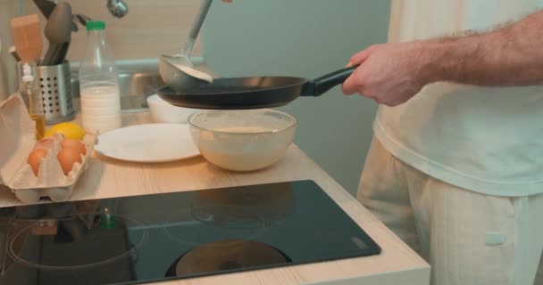 Hombre Cocinando Panqueques Fin Semana Masa Vierte Una Sartén Cerca — Vídeo de stock