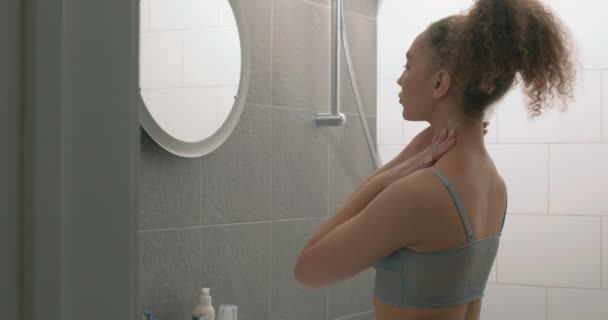 近距离后看苗条适合的女孩在脖子上涂奶油站在舒适的轻便浴室在家里 漂亮的女士用润肤液 健康与美的概念 日常皮肤护理 — 图库视频影像