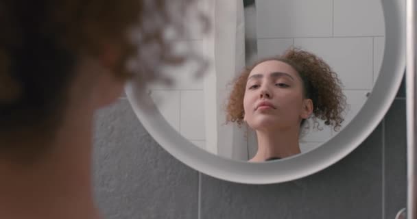 可爱的年轻女人想拥有美丽的脖子和健康的卷发 女人在浴室的特写镜头中照镜子时注意颈部反射慢动作 — 图库视频影像
