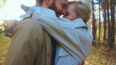 Karı koca arasındaki güçlü ilişki, mutlu, sarışın kadın ve parkta öpüşen yakışıklı sakallı adam, birlikte harika vakit geçirin, çiftler birbirlerine taparlar, romantik anlar ağır çekim