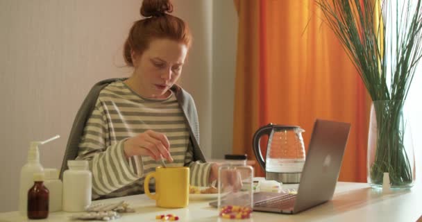生病的红头发女青年坐在笔记本电脑前的桌子前 倒热茶 喝柠檬茶 家里有流感和其他呼吸道疾病 慢动作 — 图库视频影像