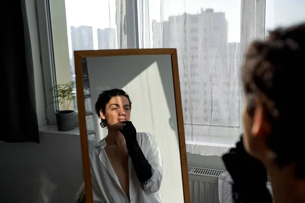 鏡の前に座りながらメイクを施すスタイリッシュなファッションマン バックビューショット 女性らしく見える — ストック写真