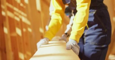 Ahşap çerçeve inşa eden çalışanlardan oluşan aktif bir ekip. Marangozlar yere tahta döşemişler. Marangozluk konsepti. Beraberlik, ahşap evleri yenilemek ve genişletmek.